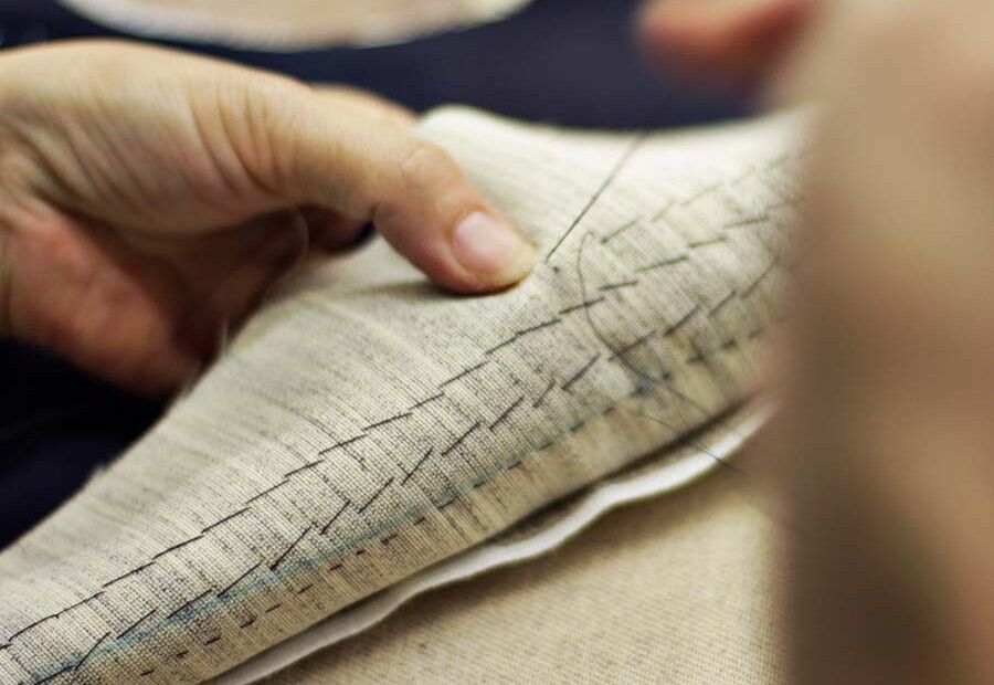 Tailor hand-stitching fabric